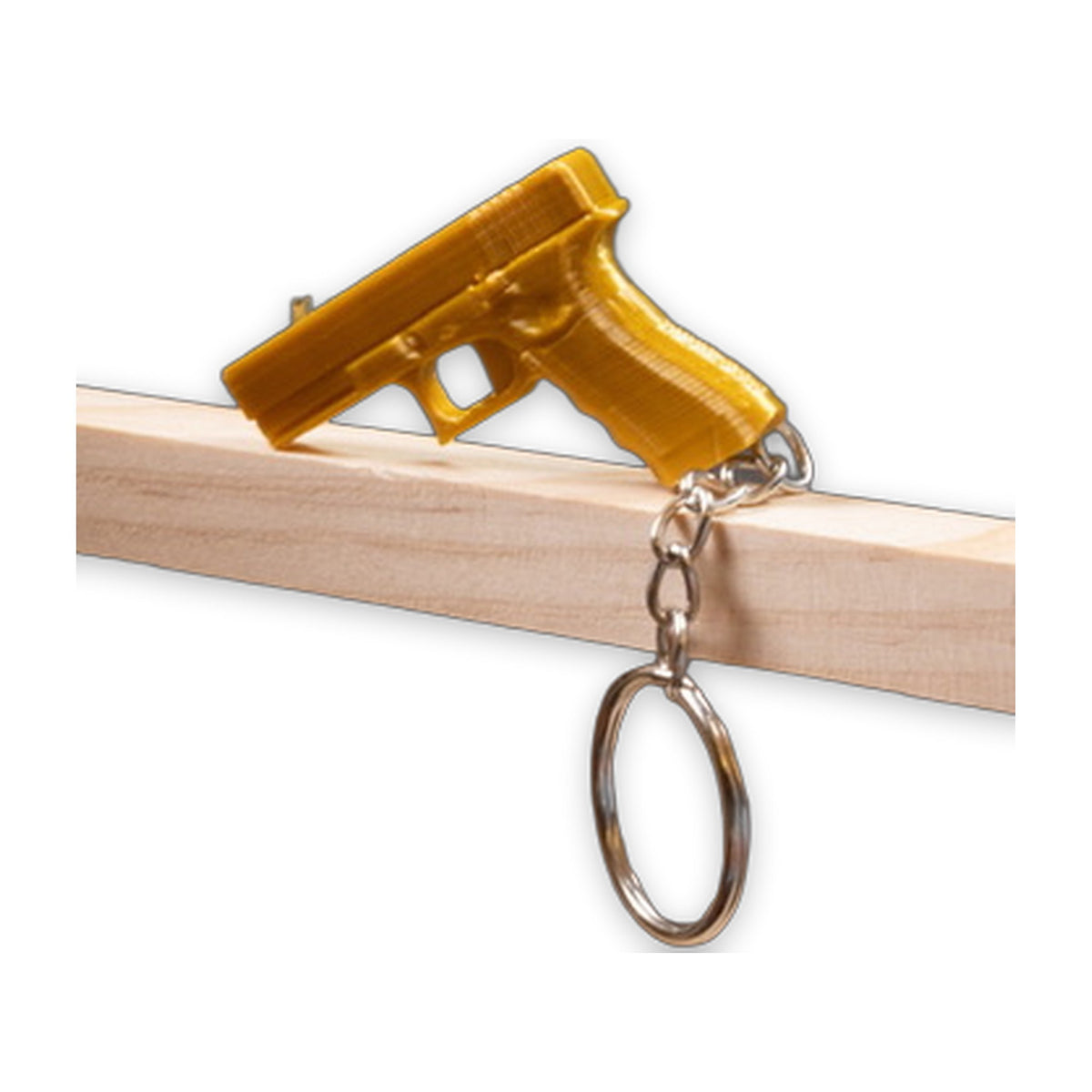 Golden pistol-shaped keychain clipped over a wooden edge