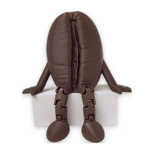 Articulated coffee bean buddy sitting on a shelf edge with legs hanging