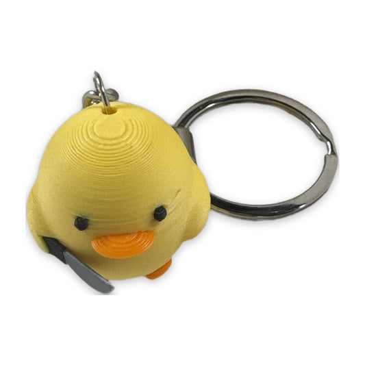Yellow meme duck keychain holding a knife